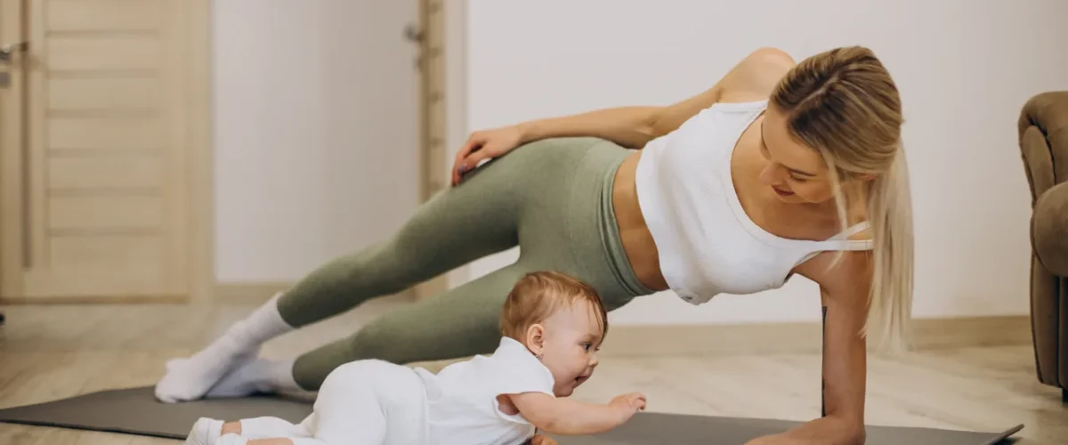 a mother in side plank next to her baby doing tummy time