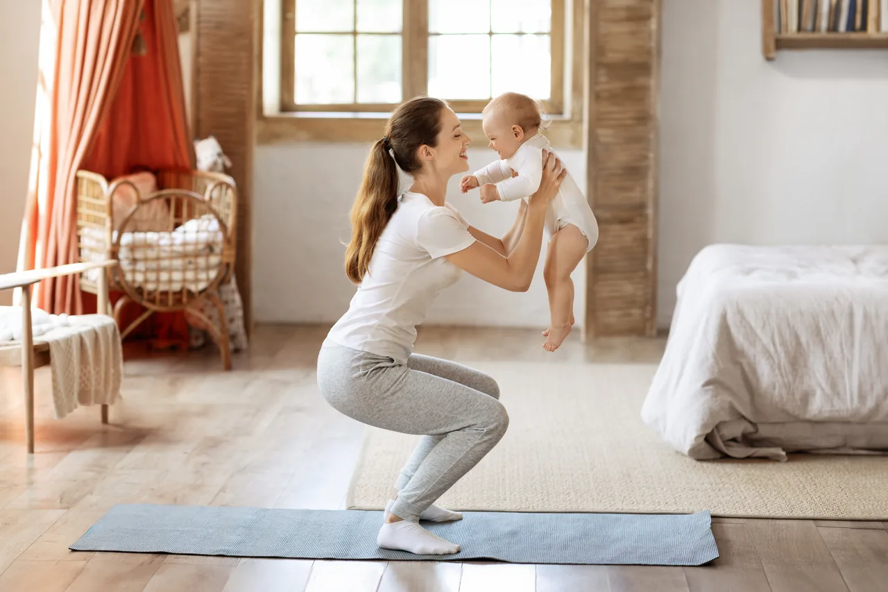 a mother squatting while lifting her baby in front of her